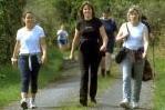 Adults walking on a wooded road.